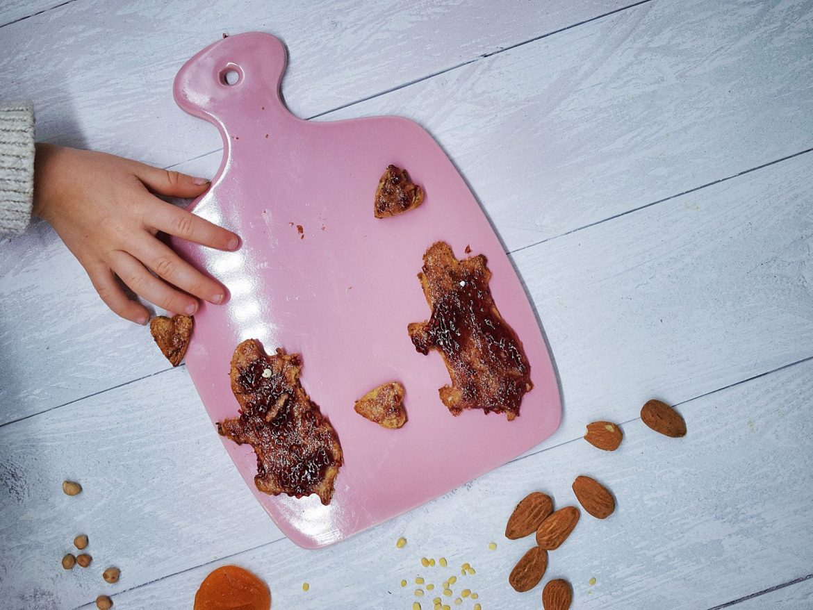 Gesunde Kinderkekse aus Haferflocken, Mandeln und Aprikosen in Schweinchenform mit Himbeermarmelade verziert