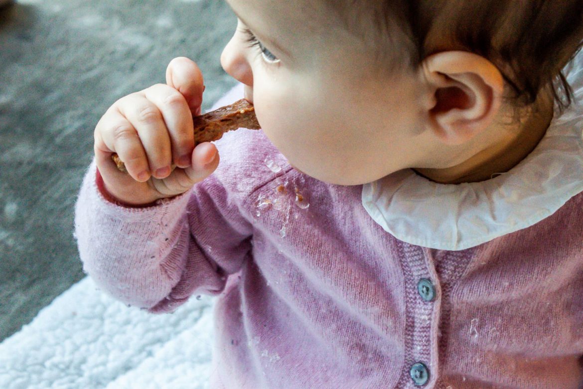 Kleinkind mit Dinkel Sticks als Snack